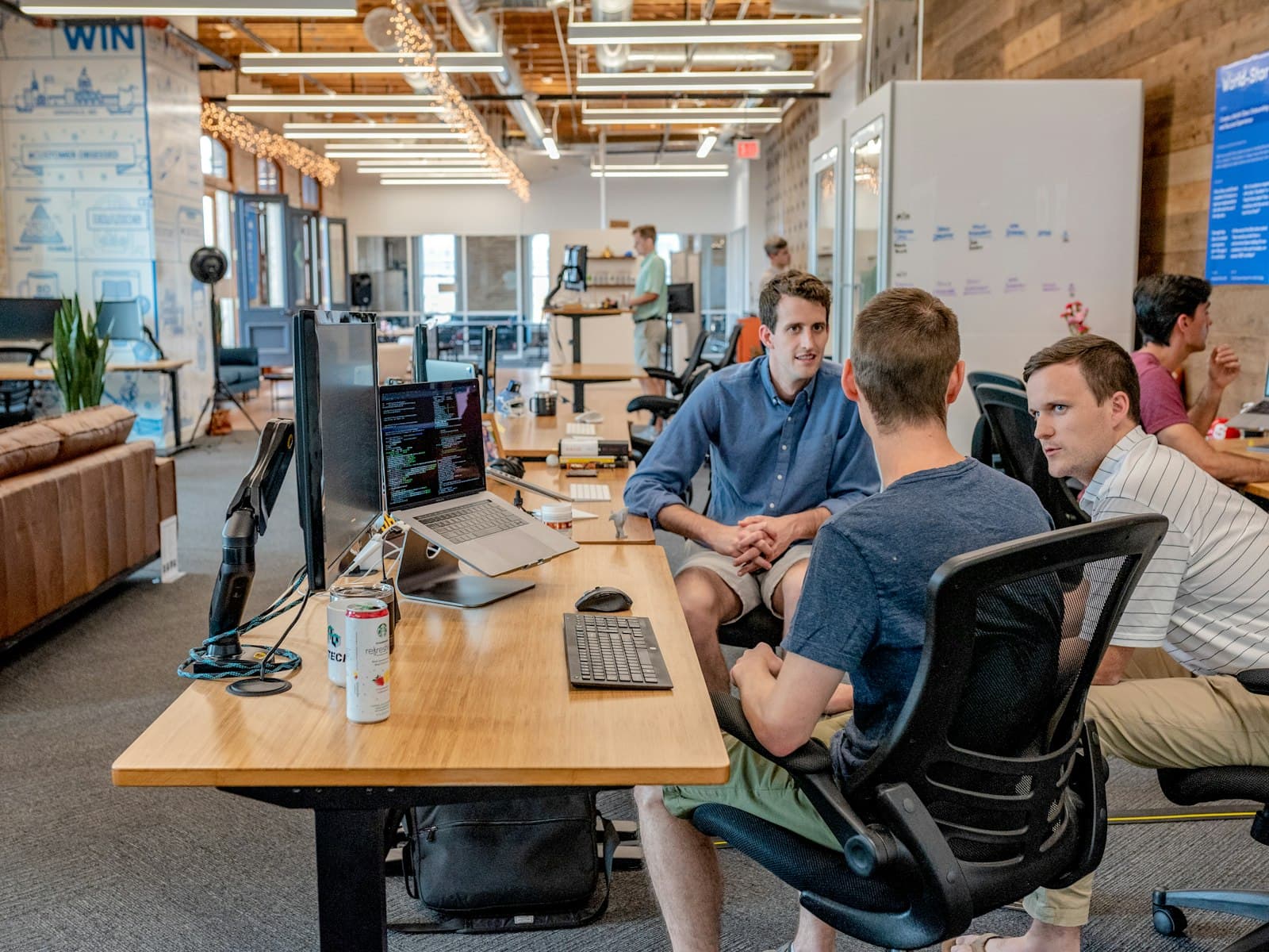 A team discussing a project around a desk in an open office