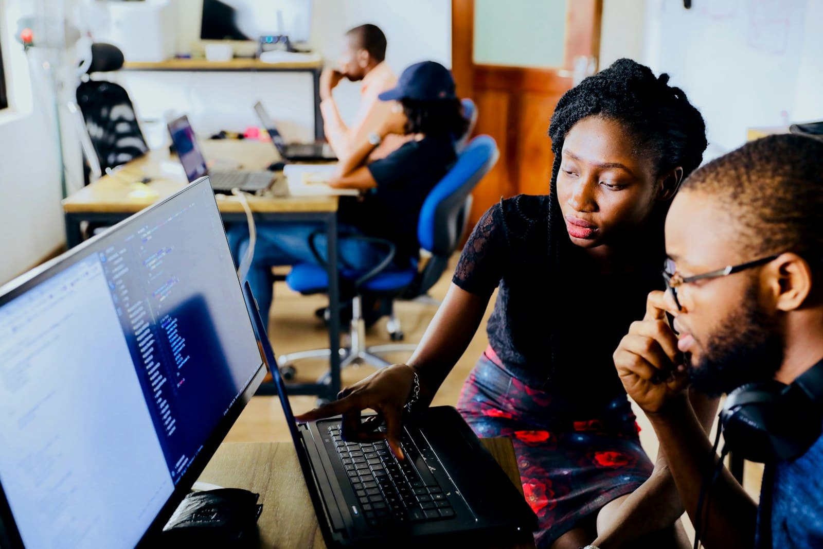 Two software engineers reviewing code together on a laptop